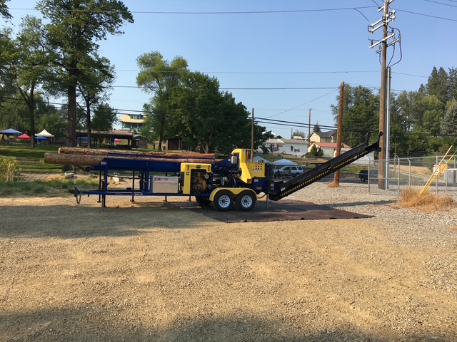 DYNA SC-15 set up on a gravel lot with whole logs loaded on the deck