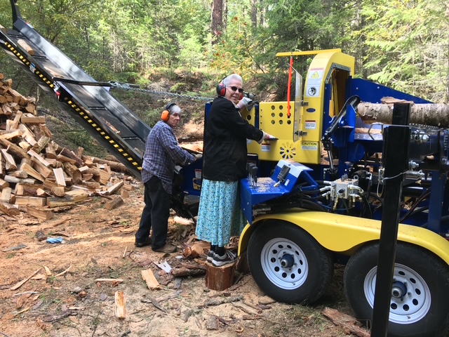 Maurice and Gail running the firewood processor in the woods wearing hearing protection