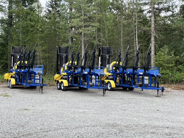 DYNA firewood processors parked on a gravel lot in the trees, ready to rent
